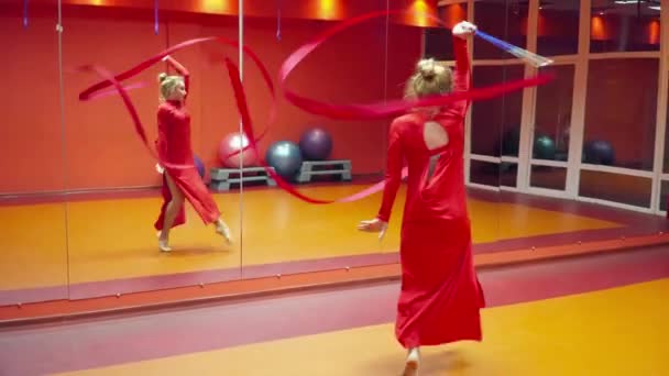Táncoló-val a szalag egy piros ruha tánc osztály fiatal tornász — Stock videók
