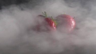 Duman siyah arka plan ağır çekim üzerinde organik taze çilek