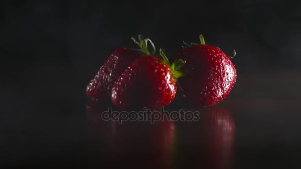 Organic fresh strawberries in smoke on the black background — Stock Video