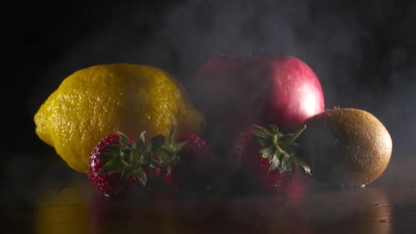 Frutti freschi e gustosi biologici in fumo sullo sfondo nero slow motion — Video Stock