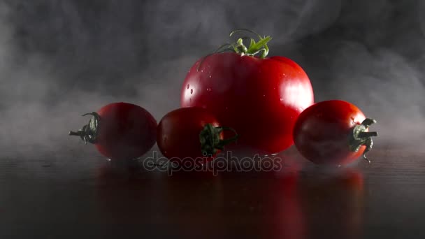 Organic fresh tasty tomatoes in smoke on the black background — Stock Video