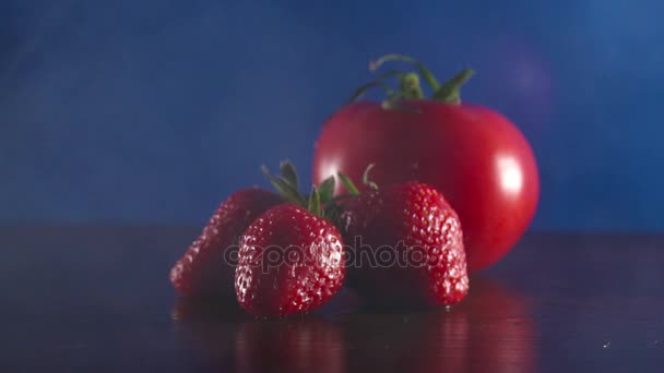 Biologische verse smakelijke tomaten en aardbeien in rook op de zwarte achtergrond — Stockvideo