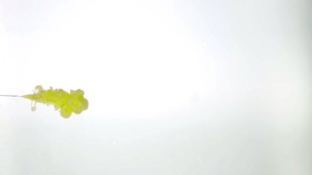 Μελάνι κίτρινο χρώμα ρίχνει στο νερό σε λευκό φόντο υφή — Αρχείο Βίντεο