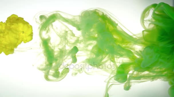 Inkt van gele en groene kleur gieten in water op witte achtergrond textuur — Stockvideo