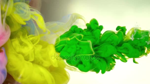 Ink of green and yellow olor pouring into water on white background texture — Stock Video