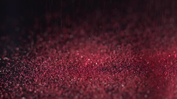 Поппово-красные блестки, падающие на черный фон, абстрактная замедленная съемка — стоковое видео