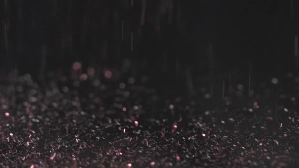 Pink chaminic sparkles falling on the black background, abstract slow motion — Stock Video