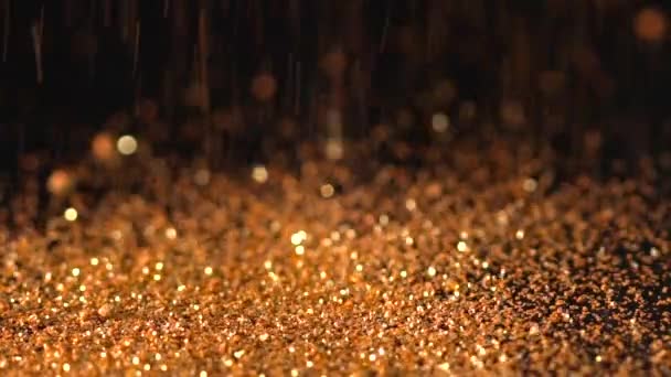 Golden orange glitter falling on the black background, abstract slow motion — Stock Video