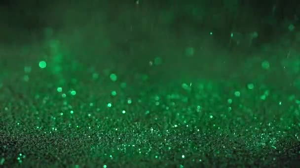 Brillo verde cayendo sobre el fondo negro, cámara lenta abstracta — Vídeos de Stock