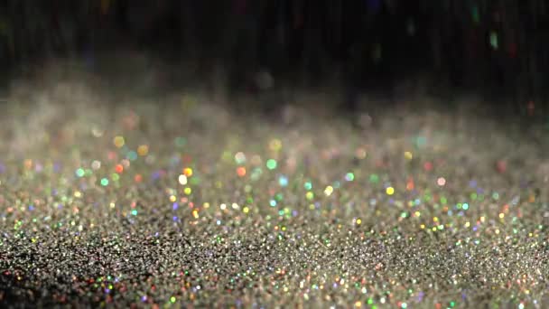 Vackra glitter faller på den svarta bakgrunden, abstrakt slowmotion — Stockvideo