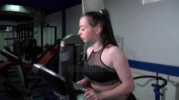 Jeune belle femme qui court sur l'elliptique — Video