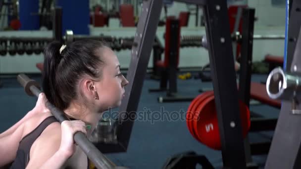 Joven morena haciendo media sentadilla en el primer plano del gimnasio — Vídeos de Stock