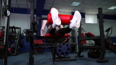 Genç kadın alttan spor salonu görünümünde bacak egzersizleri yapma