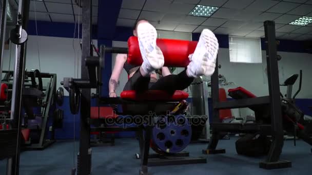 Mujer joven haciendo ejercicios de piernas en la vista del gimnasio desde abajo — Vídeo de stock