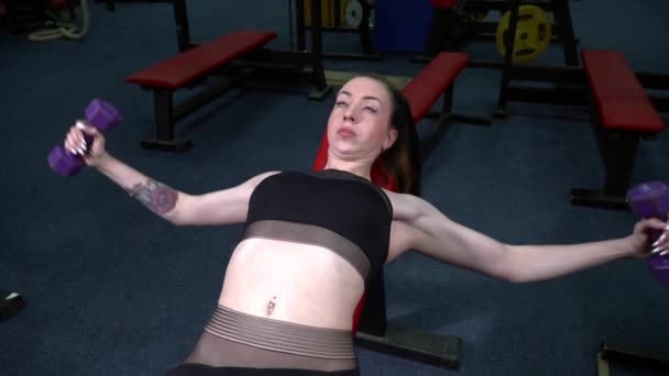 Молодая женщина тренируется с штангой в спортзале — стоковое видео