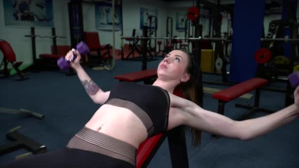 Молода красива жінка тренується з штангами в тренажерному залі — стокове відео