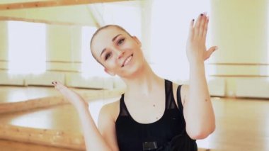 Picaboo yapma ve dans stüdyosu ağır çekimde kameraya gülümseyen güzel bir dansçı portresi