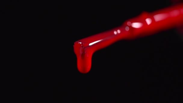 Clsoeup di uno smalto rosso che gocciola nella bottiglia al rallentatore — Video Stock