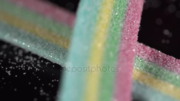 Nahaufnahme von sauren leckeren bunten Bonbons auf schwarzem Hintergrund — Stockvideo