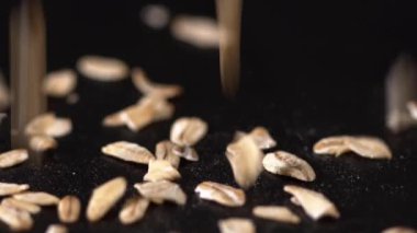 Siyah arka plan ağır çekim üzerinde düşen yulaf gevreği closeup