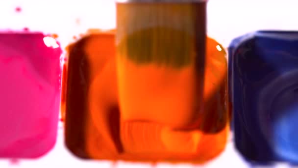 Cepillo tomando acuarela naranja de la paleta de colores primer plano cámara lenta — Vídeo de stock