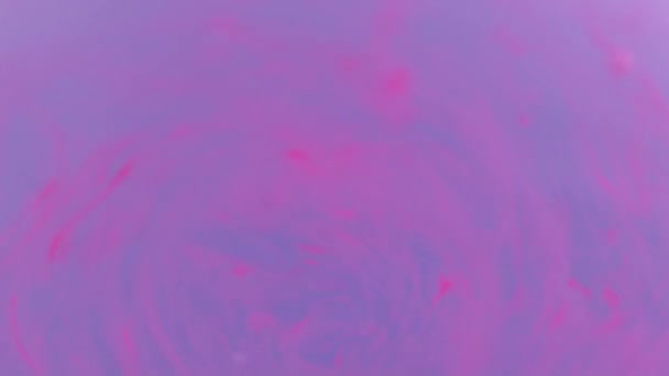 Couleur rose moussant dans l'eau et tournant à gros plan au ralenti, macro 