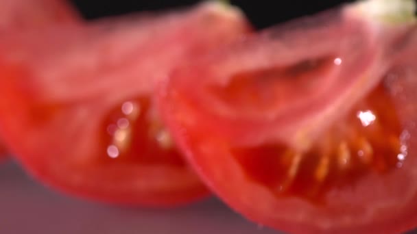 Closeup φρέσκια ντομάτα κομμένη σε μαύρο φόντο η αργή κίνηση — Αρχείο Βίντεο