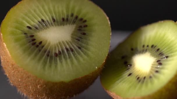 Închiderea kiwi feliat pe fundal negru — Videoclip de stoc