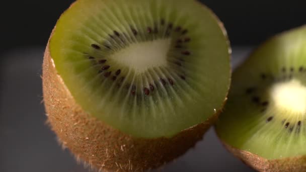 Closeup of the sliced kiwi on the black background slow motion — Stock Video