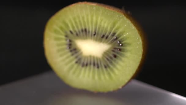 Gros plan du kiwi tranché tournant sur le fond noir — Video