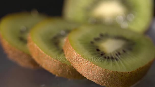 Closeup of the sliced kiwi slow motion on the black background — Stock Video