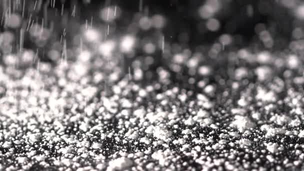 White shimmer falling on the black background, abstract slow motion — Stock Video