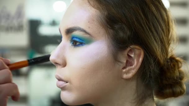 Maquillaje artista haciendo hermoso arte de la cara para una mujer con cepillo de maquillaje — Vídeo de stock