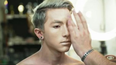 Genç adam bir yüz sanat portre için hazırlanıyor makyaj sanatçısı