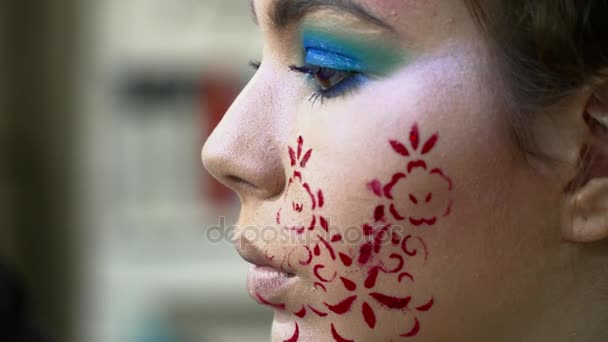 Artista de maquillaje pintando labios para una mujer con arte facial — Vídeo de stock