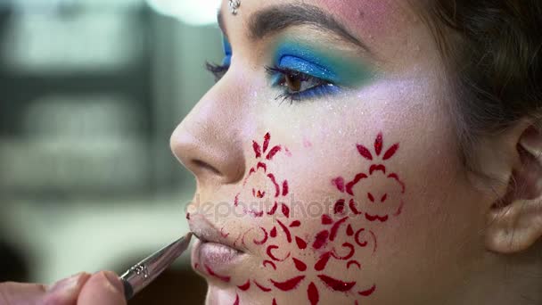 Maquillaje artista pintar labios para una mujer con cara arte primer plano — Vídeos de Stock