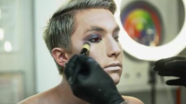 Bir adam ile bir makyaj fırça closeup için yüz sanat yapmak makyaj sanatçısı