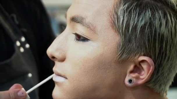 Makeup artis membuat wajah seni untuk seorang pria muda pirang closeup — Stok Video
