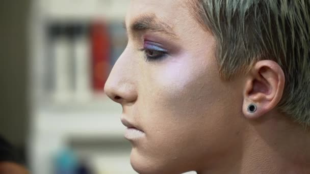 Καλλιτέχνης μακιγιάζ κάνοντας αντιμετωπίζουν την τέχνη για τον άνθρωπο μια ξανθιά με ένα closeup πινέλο μακιγιάζ — Αρχείο Βίντεο