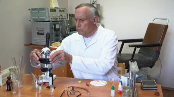 Professor que trabalha com sangue no laboratório com microscópio — Vídeo de Stock