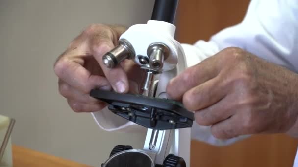 Primer plano de las manos del hombre que trabajan con el microscopio — Vídeo de stock