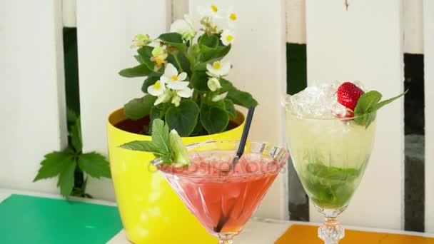 Close-up van twee cocktails op de tafel met een bloem — Stockvideo