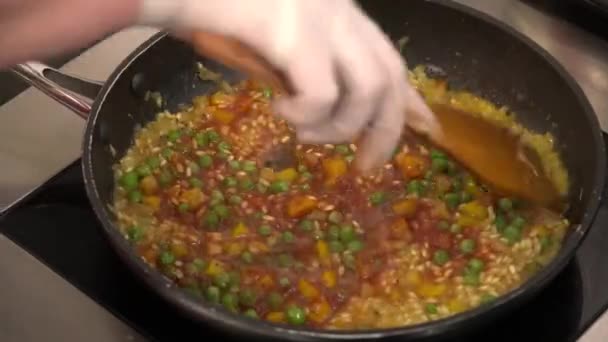 Koch rührt Reis mit Gemüse in der Pfanne — Stockvideo