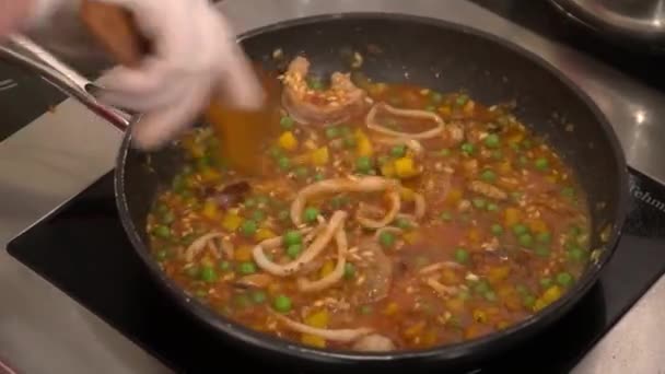 Chef stirring rice with vegetables and seafood frying on the pan — Stock Video