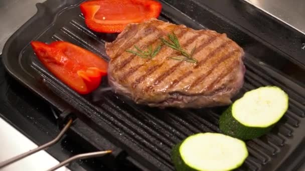 Fechar o saboroso bife grelhado na grelha com legumes — Vídeo de Stock