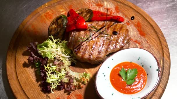 Detailní záběr na chutné grilované steaky na zpomalené deska — Stock video