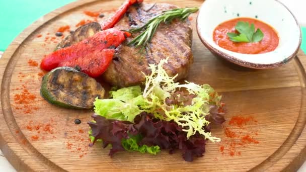 Detailní záběr na chutné grilované steaky na pohled shora deska — Stock video