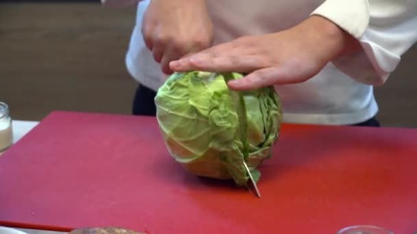 Крупный план повара, режущего капусту на доске — стоковое видео