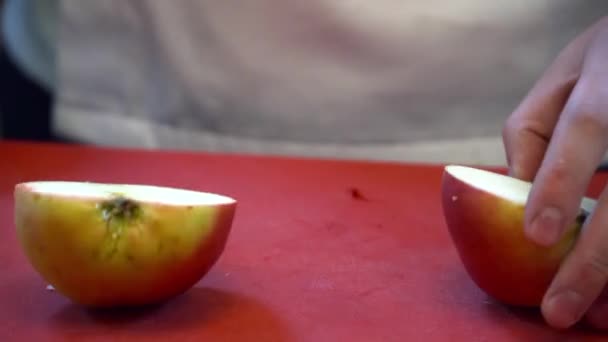 Близкий шеф-повар режет яблоко на доске — стоковое видео