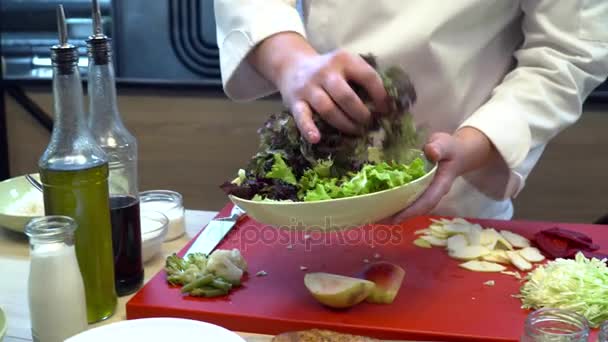 Шеф-повар делает салат с овощами на кухне — стоковое видео
